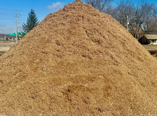 Pile of certified playground chips at Raney Tree Care's facility in Moline, IL. Safe, impact-absorbing wood chips designed for playgrounds, schools, and parks.